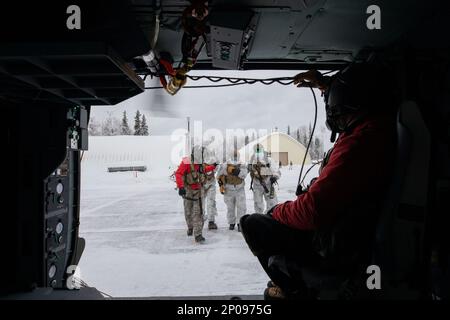 Alaska Army Guard SPC. Matthew Tucker, a sinistra, una medica di volo, e il personale Sgt. Brad McKenzie, un capo equipaggio e un operatore di sollevamento, entrambi assegnati a Golf Company, distaccamento 2, 2-211th Generale supporto Aviazione Battaglione, assistere Special Tactics Airmen, assegnato a 24th Special Operations Wing, distaccamento 1, con addestramento di evacuazione medica, A Camp Mad Bull su Joint base Elmendorf-Richardson, Alaska, 10 gennaio 2023. Gli equipaggi della Guardia militare hanno anche condotto operazioni di inserimento aereo e sollevamento con le squadre Special Tactics. Il battaglione di aviazione generale di supporto della Guardia Nazionale dell'Alaska si allena regolarmente Foto Stock