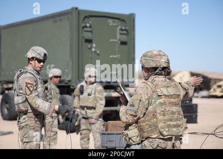 1st soldati della Divisione Armorata prendono istruzioni da un leader durante l'esercizio III del Command Post, Fort Bliss, Texas 9 febbraio 2023. Spostare il Command Post in modo rapido e sicuro è un processo complicato che richiede il coordinamento tra i soldati per il guasto e poi ristabilire il CP in un nuovo ambiente. I movimenti simulano l'ambiente affrettato dello scenario di conflitto reale, per aiutare a preparare i soldati per la battaglia. Foto Stock