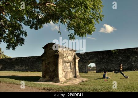 I bambini giocano a calcio su un campo d'erba dove un cimitero europeo è stato collocato vicino a Fort Speelwijk, un forte olandese costruito nel territorio di Banten Sultanato in un'area ora chiamata Banten lama (Old Banten) a Serang, Banten, Indonesia, in questa foto scattata nel 2010. Una ricerca sul campo condotta recentemente da Nurikah e E. Rakhmat Jazuli (Facoltà di giurisprudenza, Sultan Ageng Tirtayasa University, Banten) ha rivelato che ci sono state molte violazioni contro il trattamento dei beni culturali nella zona. La gente sta svolgendo attività sportive nell'ambiente dei beni culturali,... Foto Stock