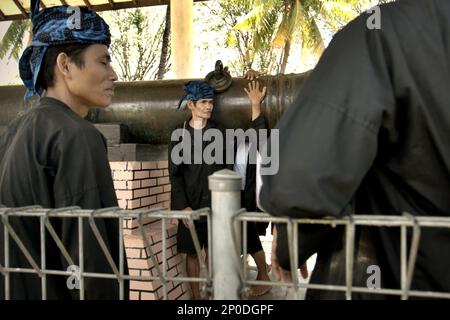 Gli uomini della comunità indigena di Urang Kanekes, popolarmente chiamata comunità Baduy Sono in visita 'Meriam Ki Amuk', un antico cannone che tradizionalmente pagano rispetto, che è uno dei beni culturali del periodo Sultanato Banten situato in una zona ora chiamata Banten lama (Old Banten) a Serang, Banten, Indonesia, in questa foto scattata nel 2010. Un team di scienziati guidati da Sunday Oladipo Oladeji ha scritto nel loro articolo di ricerca pubblicato su Sage Journals il 28 ottobre 2022, che 'la sostenibilità del patrimonio culturale è fortemente legata alla partecipazione effettiva di... Foto Stock