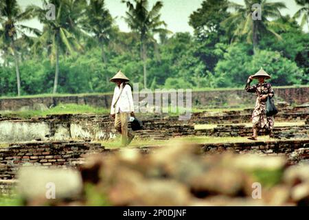 Agricoltori che camminano attraverso le rovine del Palazzo Surosowan, un patrimonio culturale del periodo Sultanato Banten situato in un'area chiamata Banten lama (Old Banten) a Serang, Banten, Indonesia, in questa foto scattata nel 2004. Una ricerca sul campo condotta recentemente da Nurikah e E. Rakhmat Jazuli (Facoltà di giurisprudenza, Sultan Ageng Tirtayasa University, Banten) ha rivelato che ci sono state molte violazioni contro il trattamento dei beni culturali nella zona. Foto Stock