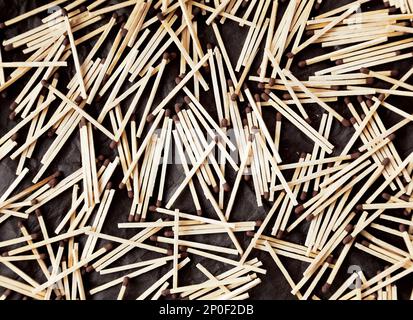 Molti domestici di legno fiammiferi di sicurezza con teste di marrone giacente caoticamente su sfondo nero Foto Stock