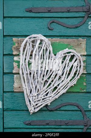 Cuore decorativo fatto di ramoscelli su un vecchio cancello di legno, Assia, Germania Foto Stock