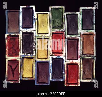 Set di vecchie pitture acquerello usate primo piano sfondo artistico. Uno degli strumenti d'arte: Tavolozza colori sfondo motivo scuro Foto Stock