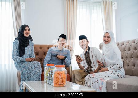 Due coppie musulmane sorridenti alla macchina fotografica il giorno di Eid Foto Stock