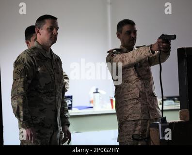 Una piccola coorte della Brigata Armorata del 15th, Kuwait Land Forces, guidata dal Colon. Al-Mekhyal, comandante, visita Camp Arifjan per praticare il tiro al Engagement Skills Trainer, un sistema simile a un videogioco per le abilità con le armi. Il col. Martin Wohlgemuth, comandante, Area Support Group - Kuwait, e il comando Sgt. Major Leon Black, NCOIC, ASG-KU, li ospitano spiegando il valore e il potenziale del sistema EST. Kuwait e soldati americani praticano la M9 pistola e il M4 fucile a Camp Arifjan, Kuwait, 26 gennaio 2023. Foto Stock