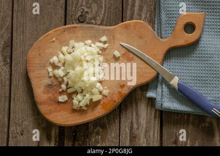 la cipolla tritata si trova su una tavola di legno Foto Stock