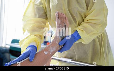 Stoccarda, Germania. 14th Feb, 2023. Un'infermiera si prende cura dei piedi di un paziente in una stanza dell'ospedale di Stuttgart Credit: Bernd Weißbrod/dpa/Alamy Live News Foto Stock