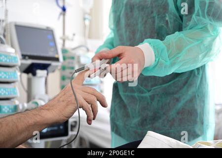 Stoccarda, Germania. 14th Feb, 2023. Un infermiere applica un dispositivo di misurazione a un paziente in una stanza dell'ospedale di Stoccarda. Credit: Bernd Weißbrod/dpa/Alamy Live News Foto Stock