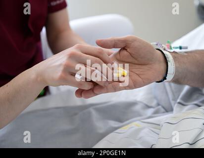 Stoccarda, Germania. 14th Feb, 2023. Un infermiere dà i tablet a un paziente in una stanza dell'ospedale di Stoccarda. Credit: Bernd Weißbrod/dpa/Alamy Live News Foto Stock