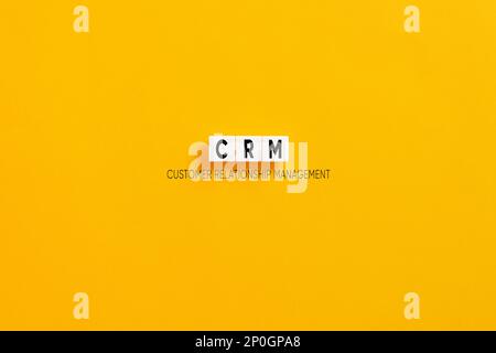 Blocchi di lettere bianchi su sfondo giallo con l'acronimo CRM Customer Relationship Management. Concetto di marketing aziendale. Foto Stock