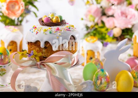 Impostazione tavolo di Pasqua festivo. Torta di Pasqua, uova di Pasqua, arrangiamenti di fiori e decorazioni per la casa per le vacanze. Foto Stock