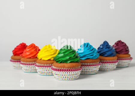 Molti deliziosi cupcake colorati su un tavolo bianco. Spazio per il testo Foto Stock