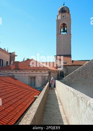 Le mura di Dubrovnik passano con due turisti davanti in Croazia Foto Stock