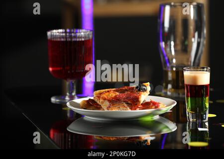 Luminoso delizioso shot in bicchiere e pizza sul tavolo Foto Stock