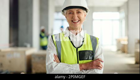 Donna anziana, architetto e sorridere con le braccia incrociate in successo per l'architettura industriale o cantiere. Ritratto di donna anziana fiduciosa Foto Stock