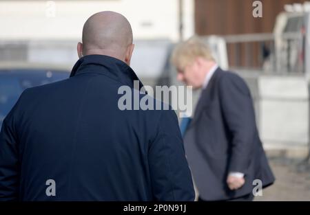 Una guardia di sicurezza guarda su come l'ex primo ministro Boris Johnson MP arriva al Queen Elizabeth II Conference Centre a Westminster per consegnare un sp Foto Stock
