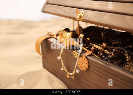 Cassettiera aperta in legno sulla spiaggia sabbiosa, primo piano Foto Stock