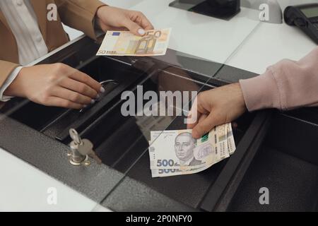 Uomo che scambiano denaro presso la finestra del reparto contanti, primo piano Foto Stock