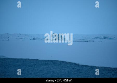 Formazioni di iceberg nella parte gelata della laguna di Jokulsarlon in una giornata grigia con scarsa visibilità. Foto Stock