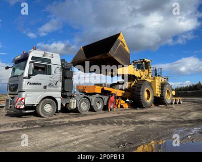 Trasporto della pala gommata di grandi dimensioni al prossimo cantiere minerario, trasporto pesante Foto Stock