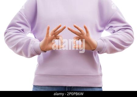 Il colpo corto di una donna in una felpa oversize di lavanda sta mostrando il segno di ok. Foto Stock