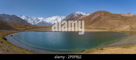 Panorama paesaggistico vicino al campo base Achik Tash di Lenin Peak in Trans-Alay o Trans-Alai catena montuosa con lago in primo piano, Sary Mogol, Kirghizistan Foto Stock