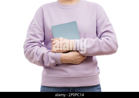 Foto ritagliata di una donna in una felpa oversize di lavanda, con un blocco note in mano. Foto Stock