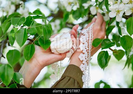 Delicati tamponi in cotone con pizzo sullo sfondo delle foglie. Foto Stock