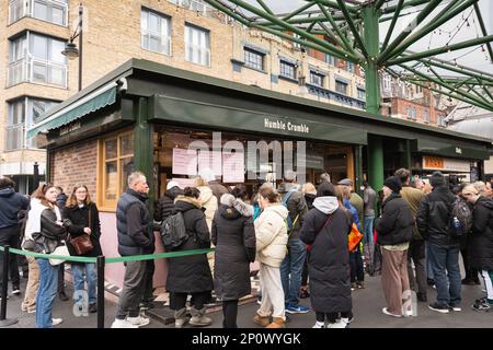 Lunghe code di persone fuori dall'umile bancarella e chiosco del mercato, Borough Market, Southwark, Londra, Inghilterra, REGNO UNITO Foto Stock