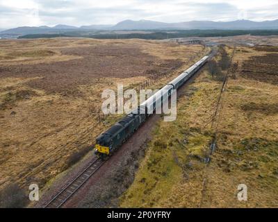 Vista aerea dal drone del treno Caledonian Sleeper che si avvicina alla stazione di Rannoch su Rannoch Moor a Perth e Kinross, Scozia, Regno Unito Foto Stock