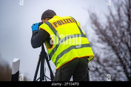 PRODUZIONE - 02 marzo 2023, Meclemburgo-Pomerania occidentale, Gützkow: Un poliziotto esamina la scena del crimine all'incrocio di Gützkow. Dopo la spettacolare rapina di un camion in transito che trasportava milioni di bottini nel Meclemburgo-Pomerania occidentale, i responsabili sono ancora in corsa il venerdì. Foto: Str/dpa Foto Stock