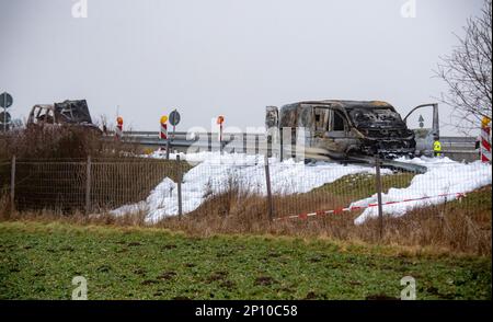 PRODUZIONE - 02 marzo 2023, Meclemburgo-Pomerania occidentale, Gützkow: Al bivio di Gützkow si trova un pulmino di transito in contanti (r) bruciato. Dopo la spettacolare rapina di un trasportatore di denaro con milioni di bottini nel Meclemburgo-Pomerania occidentale, i colpevoli sono ancora in corsa il venerdì. Foto: Str/dpa Foto Stock