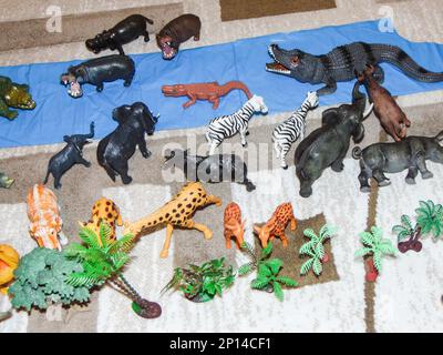 Animali giocattolo africani posti su tappeto da un bambino Foto Stock