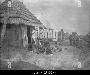 Ainu donne e bambini al di fuori di una capanna, 1908. Foto Stock