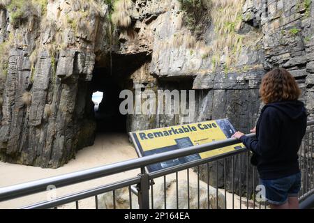 Grotte notevoli una grotta marina sotto le scogliere collega la riva al mare, scavata dalle onde. Un visitatore vede questa caratteristica geologica dalla piattaforma. Foto Stock