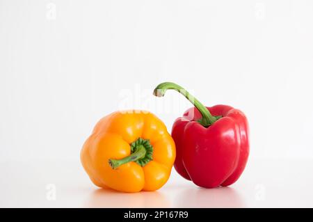 Peperoni rossi e gialli maturi in studio per primo piano isolato su bianco. Foto Stock