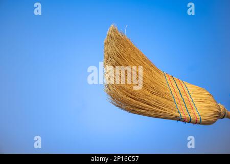 Dettaglio primo piano della scopa intrecciata isolato su sfondo blu. Foto Stock
