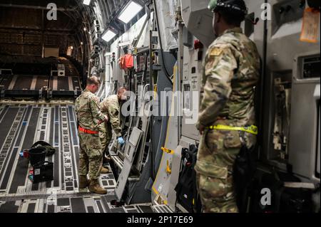 Staff Sgt. Michael White, 15th manutenzione aeromobili Squadron capo equipaggio volante, e Airman 1st Classe Cameron Williams, 15th AMXS capo equipaggio, istruire Capo Master Sgt. Anthony Thompson Jr., 15th Wing capo comando, mentre idro-serving un C-17 Globemaster III alla base congiunta Pearl Harbor-Hickam, Hawaii, 26 gennaio 2023. AMXS è responsabile della manutenzione della linea di volo necessaria per il lancio e il recupero delle tristezze. Foto Stock