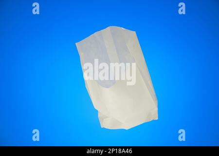 Piccolo sacchetto di carta bianca aperto sandwich shot studio isolato su sfondo blu. Foto Stock