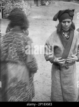 Due donne Ainu nella corsia del villaggio, 1908. Foto Stock