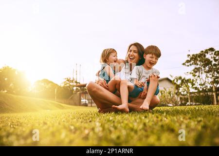 I suoi ragazzi riempiono la sua vita di gioia. Scatto corto di una famiglia giovane che passa il tempo insieme all'aperto. Foto Stock