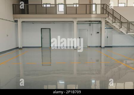 Nuovo rivestimento del pavimento in resina e segni di marcatura in un'officina automobilistica. Foto Stock