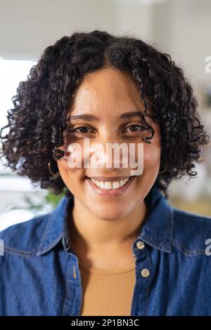 Ritratto di felice donna biraciale guardando la macchina fotografica e sorridendo Foto Stock