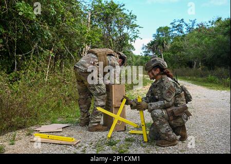 STATI UNITI Air Force Senior Airman Anthony Bragg e U.S. Air Force Senior Airman Ashley Nieves, membri della squadra antincendio con lo Squadron delle forze di sicurezza 736th, ha creato barriere stradali sul Pacific Air Forces Regional Training Center-Andersen Air Force base, Guam, 19 gennaio 2023. Il 36th Contingency Response Group ha collaborato con lo squadrone Airlift 36th della base aerea di Yokota, Giappone, per condurre un'esercitazione di addestramento sul campo che ha testato il funzionamento in un ambiente austero. Le unità hanno condotto una varietà di scenari di addestramento, come la configurazione di porte aeree/aeree, l'esecuzione di operazioni di zona di caduta, la creazione di letto Foto Stock