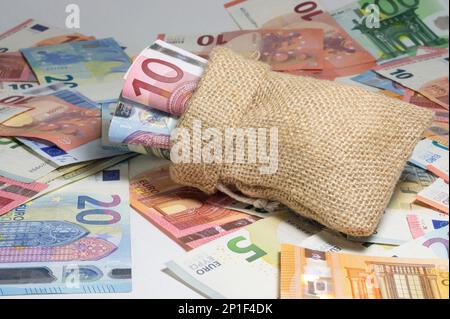 borsa piena di soldi. banconote sparse. Foto Stock