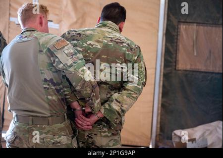 STATI UNITI Air Force Airman 1st Class Jeffrey Leitch, 724th Expeditionary Air base Squadron Civil Engineer Flight, Water and Fuel Systems Maintenance Technician, posiziona manette su un arretee simulato durante l'addestramento delle forze di sicurezza presso AB 201, Niger, 27 gennaio 2023. Gli Augmentee sono radunati da varie unità al di fuori dei loro campi di carriera per diventare Airmen multifunzionale - potere funzionare come membri delle forze di sicurezza nei periodi di bisogno. Foto Stock