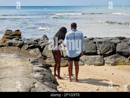 Waikiki, Oahu, Hawaii, USA, - Febbraio 6, 2023: Giovane coppia afro-americana in piedi sulla spiaggia di Waikiki Foto Stock
