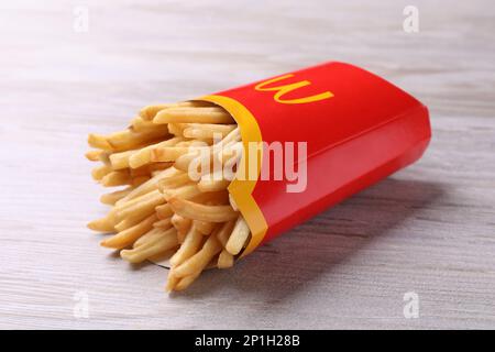 MYKOLAIV, UCRAINA - 12 AGOSTO 2021: Gran parte delle patatine fritte di McDonald's su un tavolo di legno bianco Foto Stock