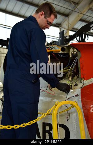 STATI UNITI Coast Guard Petty Officer 2nd Class Evan Daniels, un tecnico elettrico dell'avionica (AET) assegnato alla Air Station Clearwater, Fla., ispeziona l'impianto antincendio su un elicottero Coast Guard MH-60T Jayhawk mentre si trova alla Air Station Clearwater il 18 gennaio 2023. Gli AET ispezionano, assistono, gestiscono, risolvono i problemi e riparano i sistemi avionici che eseguono le funzioni di comunicazione, navigazione, prevenzione delle collisioni, acquisizione dei target e controllo automatico del volo. Foto Stock